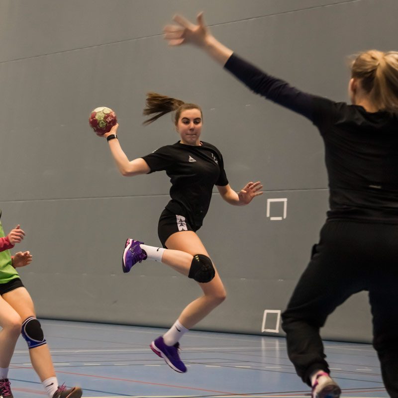 Jenter som spiller håndball innendørs